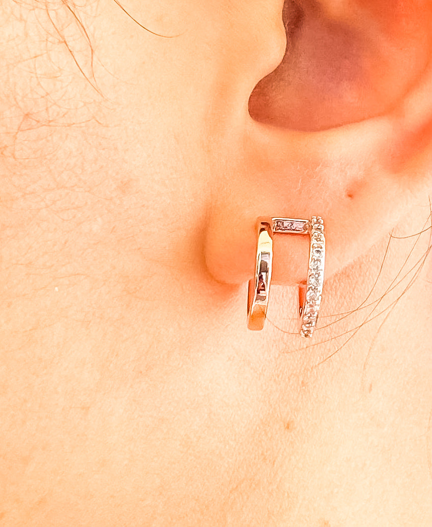 Lifestyle image of model wearing rose gold huggie earrings