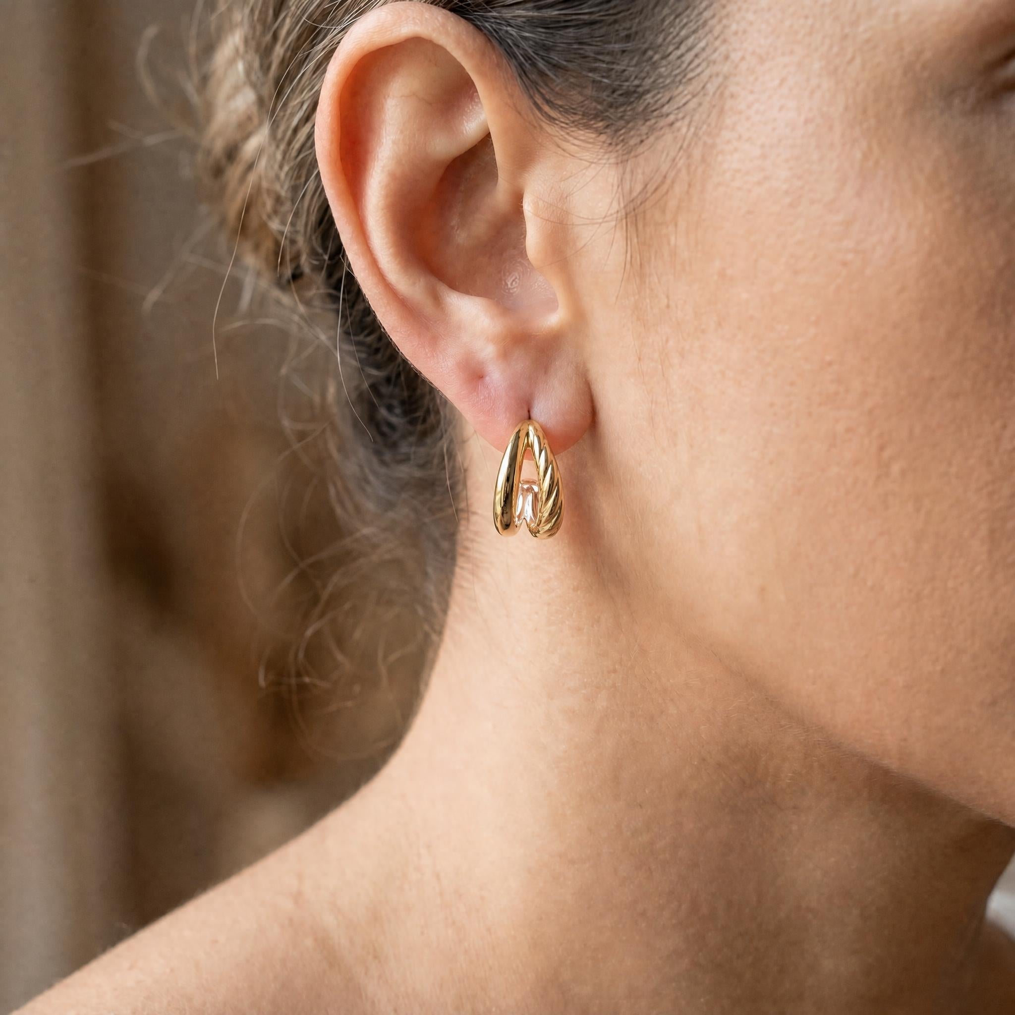 Close up of Double C shape twist earring on a model